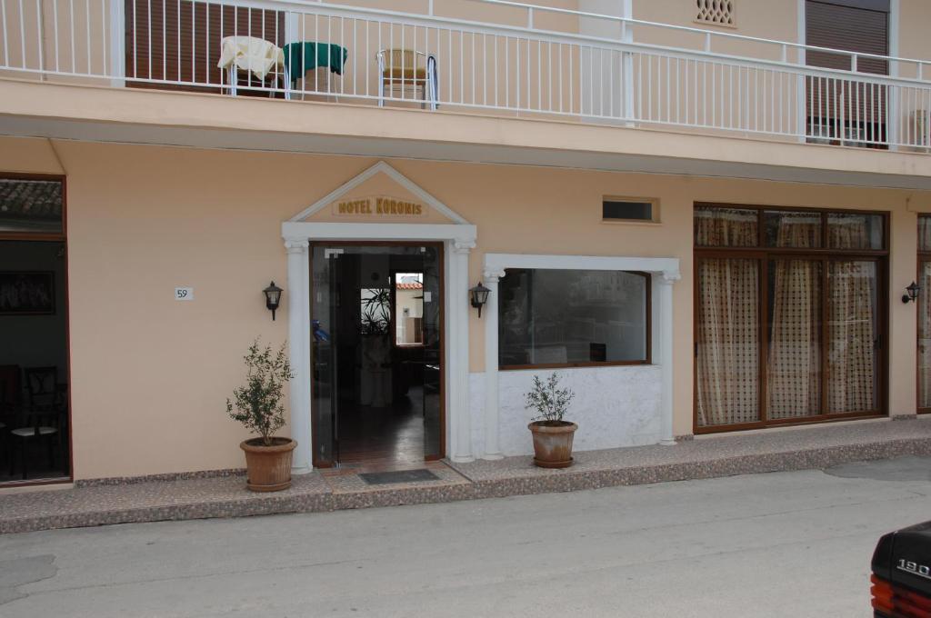a building with a entrance with a cow on a balcony at Koronis Hotel in Tolo