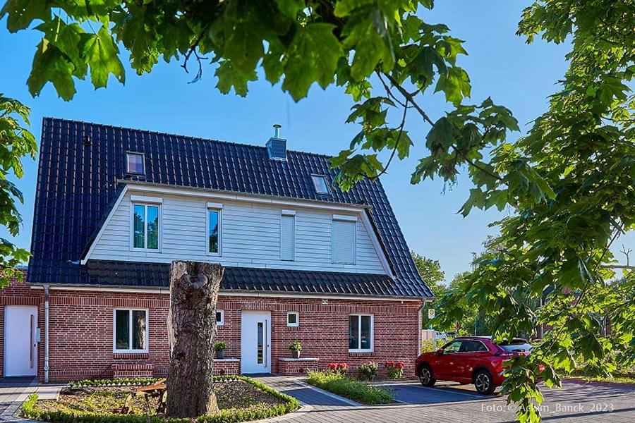 un coche rojo estacionado frente a una casa de ladrillo en Hotel aanders en Neumünster