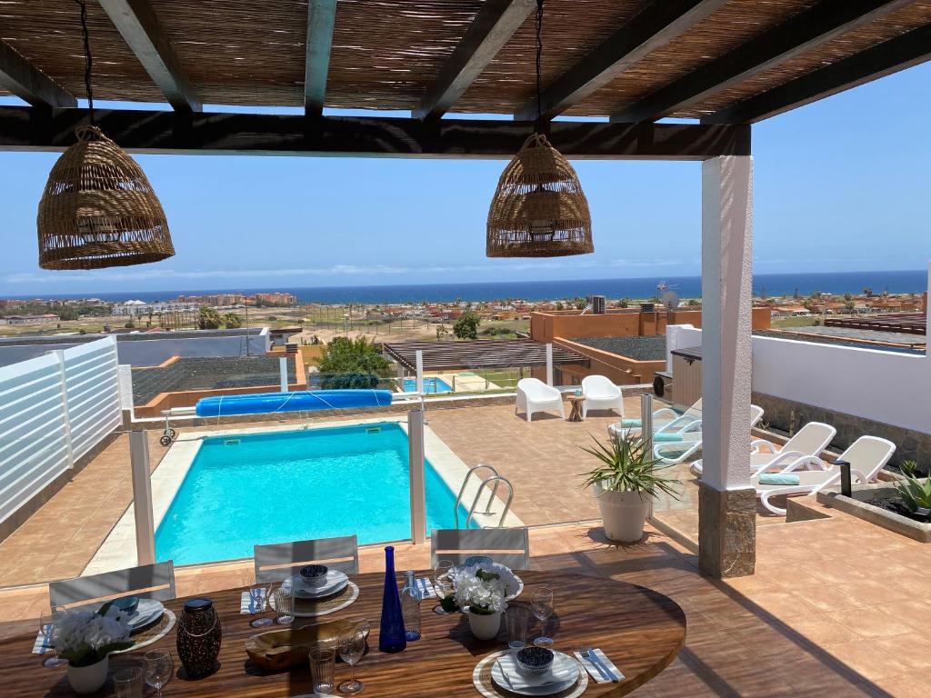 a villa with a swimming pool on a roof at Casa Blanca Caleta - Golf & Sea Views - private heated Saltwater Pool - BBQ - Aircondition" in Caleta De Fuste
