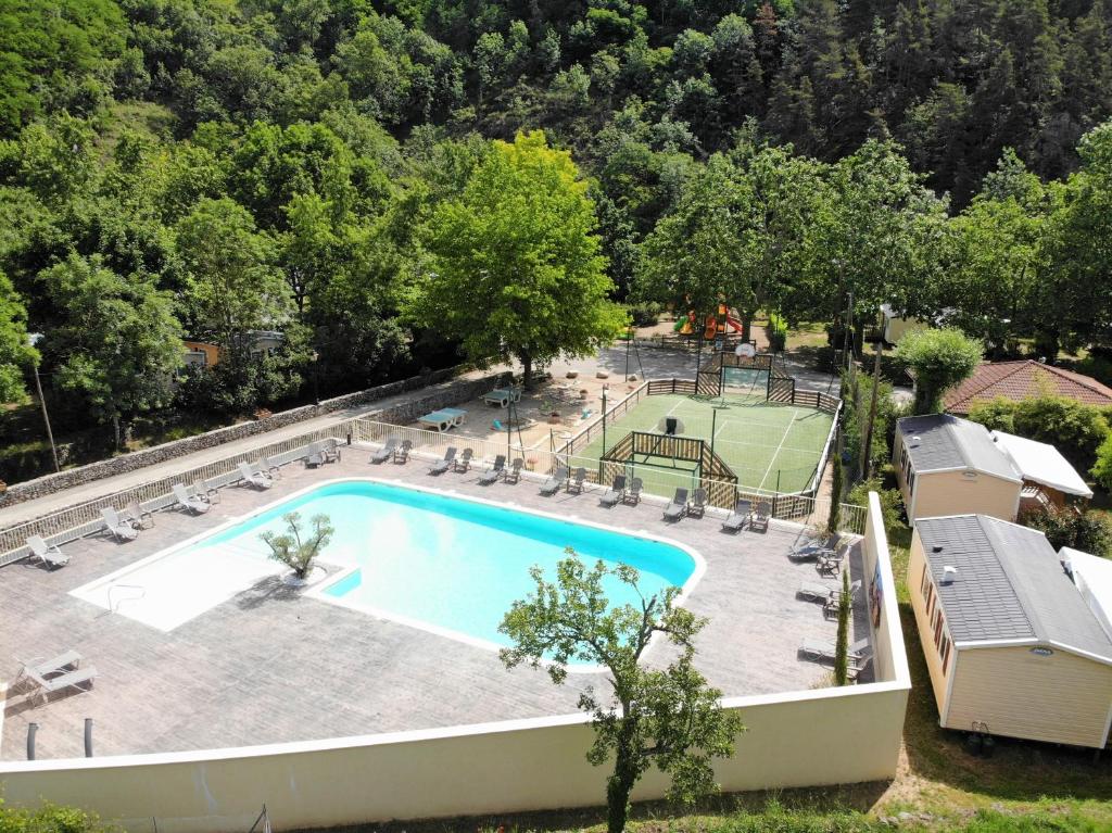 - une vue sur la piscine et le court de tennis dans l'établissement Camping de Retourtour, à Lamastre