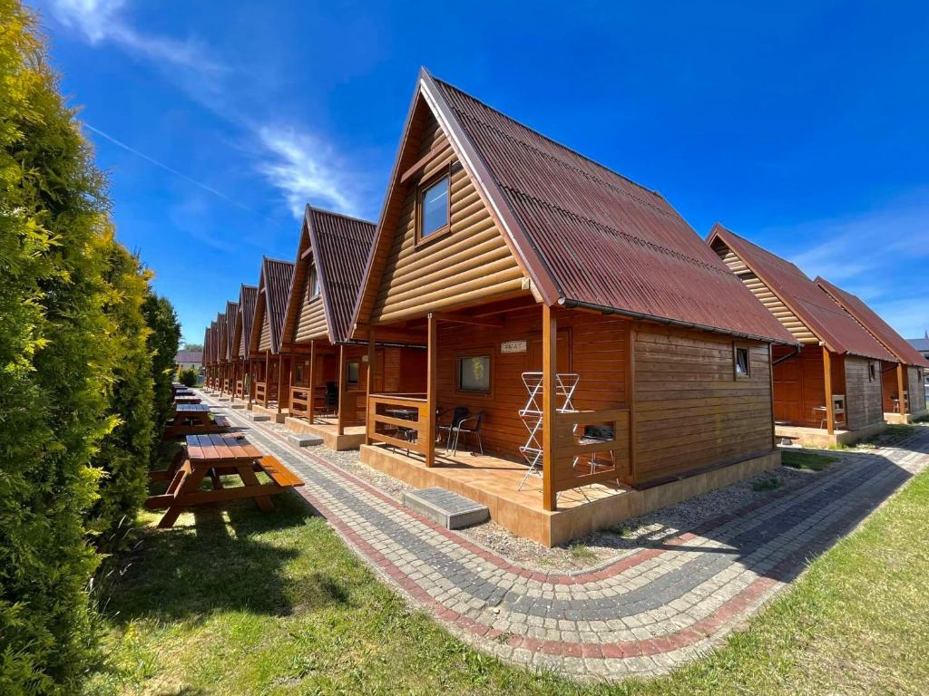 a row of log cabins at a resort at Rega domki in Sarbinowo
