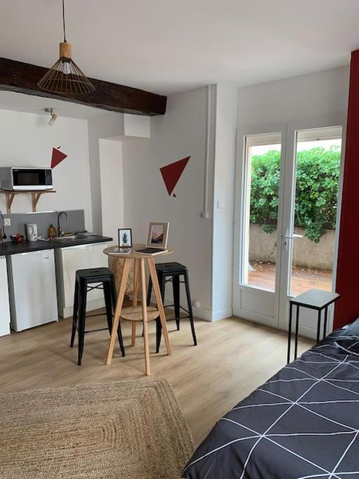 un salon avec une table et une cuisine dans l'établissement Le Terracotta : au coeur du centre historique, à Dijon