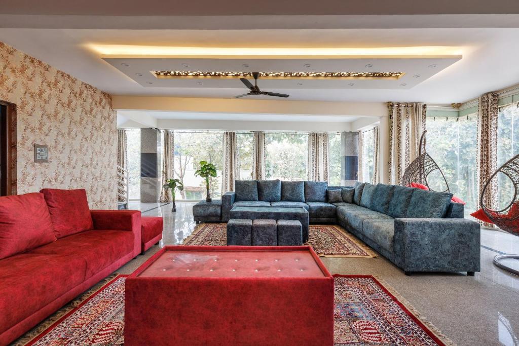 sala de estar con sofás y sofá rojo en Rustica Villa By JadeCaps 7BHK 2Pvt Pool Projector en Denkanikottai
