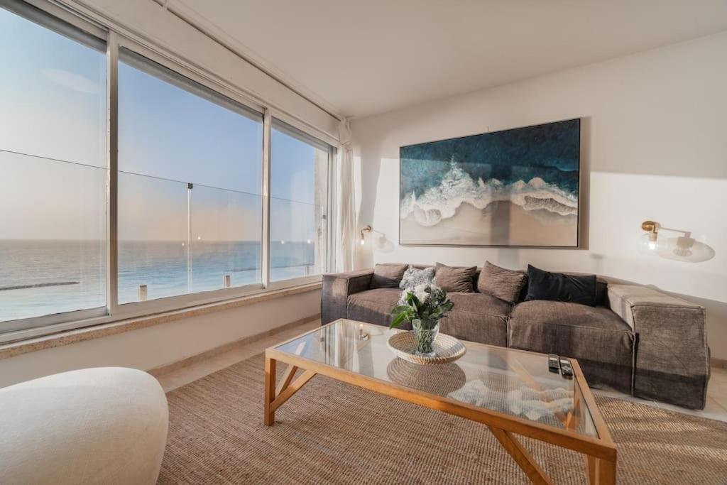sala de estar con sofá y mesa en Beachfront apartment with breathtaking sea view, en Netanya