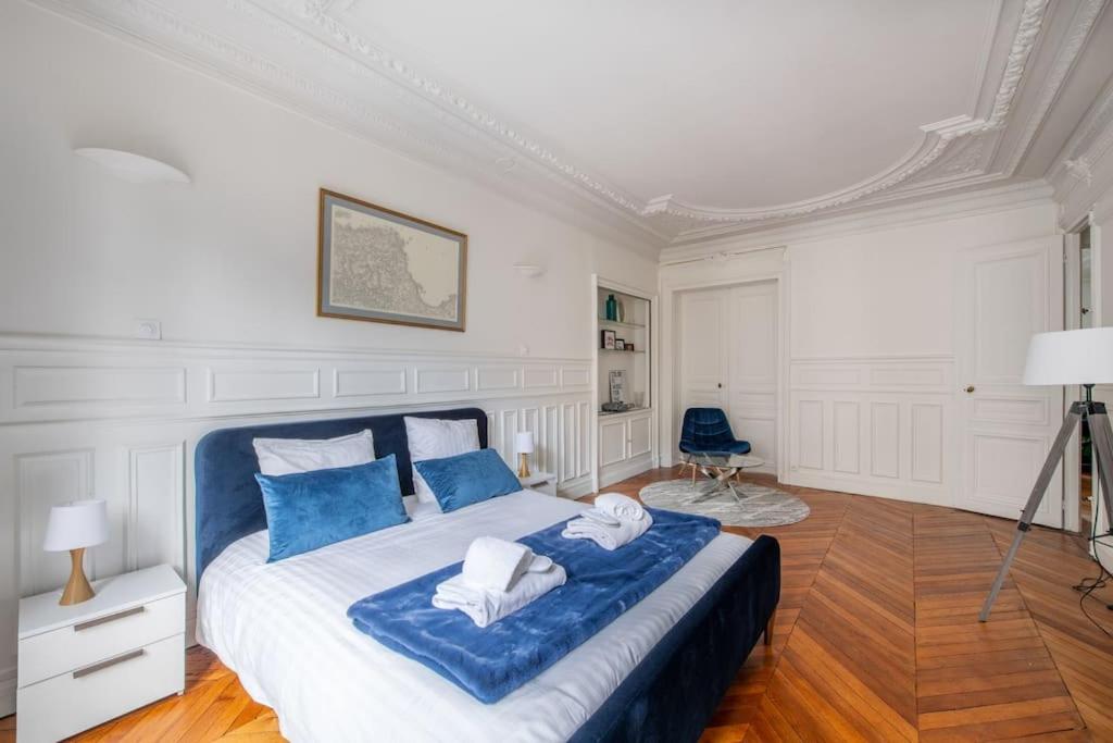 a bedroom with a large bed with blue pillows at République - Magnifique appartement au centre de Paris in Paris