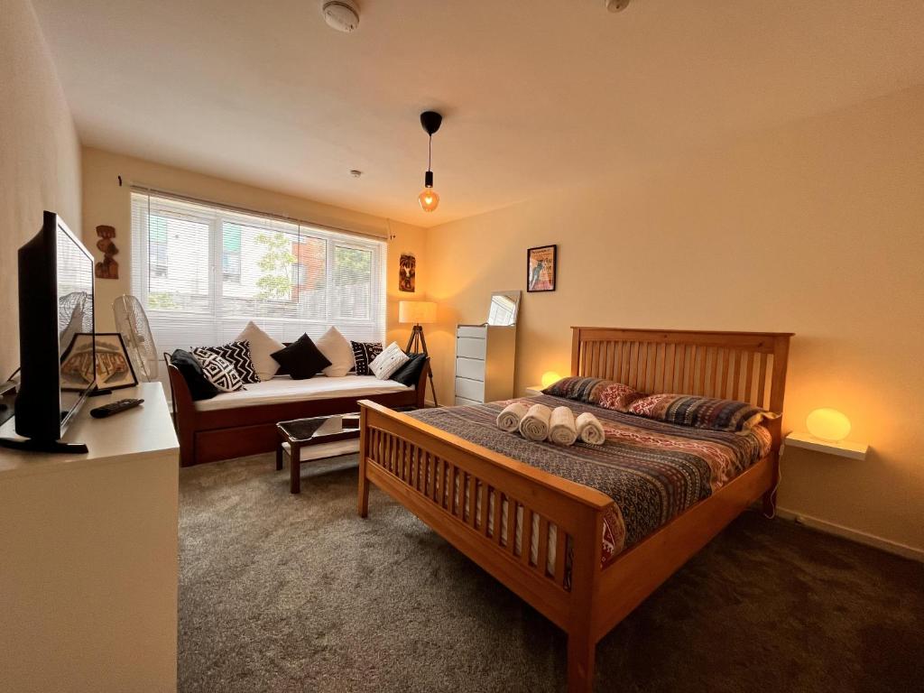 a bedroom with a bed and a couch at Millfields Place in London