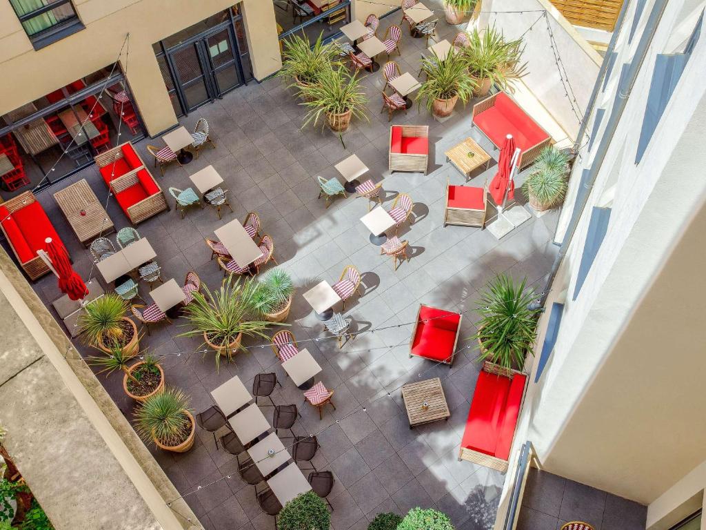 Elle offre une vue sur la terrasse dotée de chaises et de plantes. dans l'établissement ibis Styles Montpellier Centre Comedie, à Montpellier