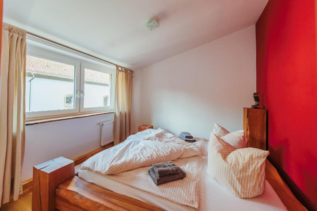 Schlafzimmer mit einem Bett und einem Fenster in der Unterkunft Alte Kass in Neidlingen