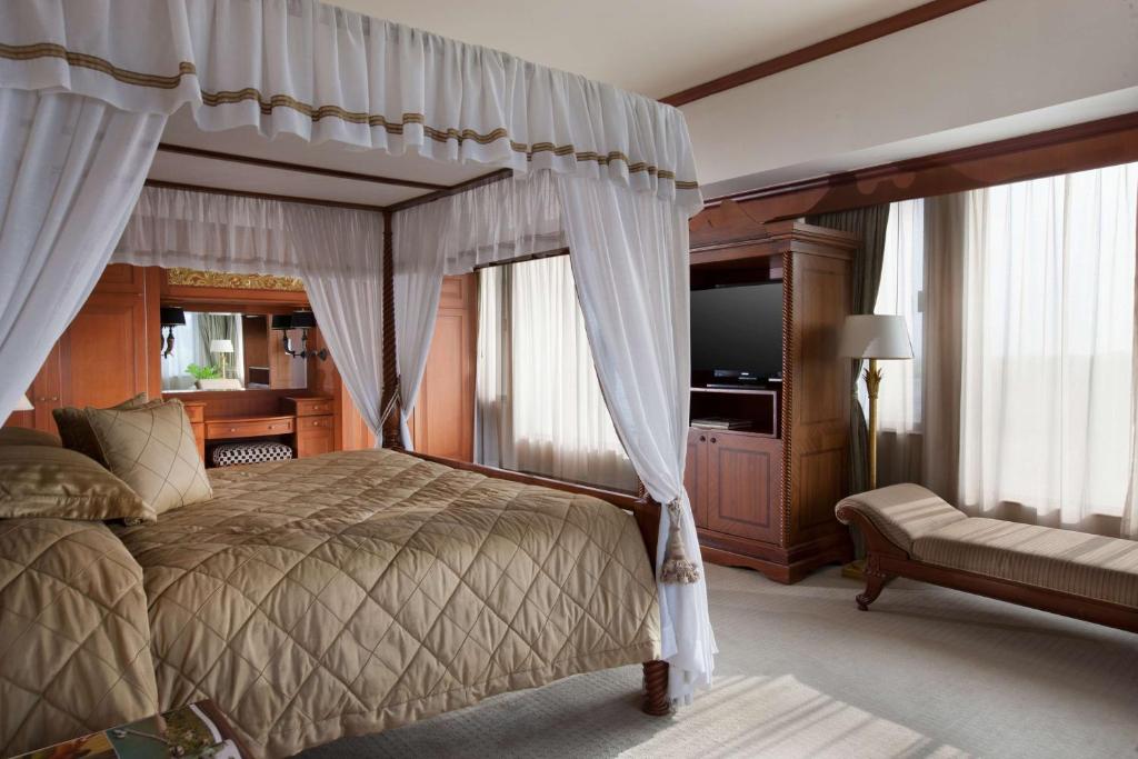a bedroom with a canopy bed and a television at Hyatt Regency Yogyakarta in Yogyakarta