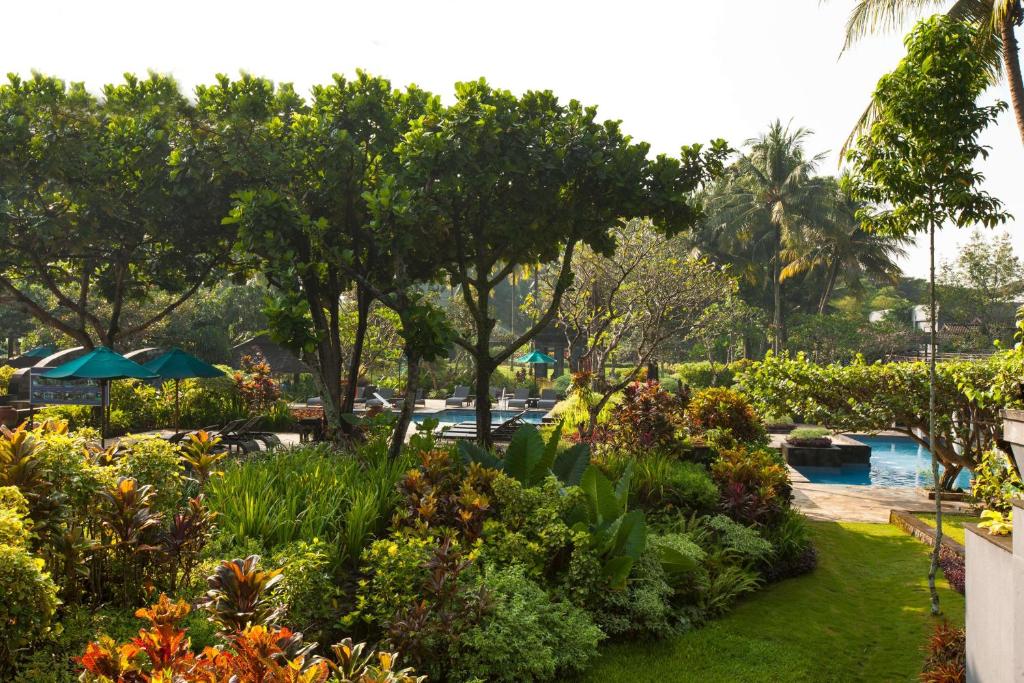 a garden with flowers and trees and a pool at Hyatt Regency Yogyakarta in Yogyakarta