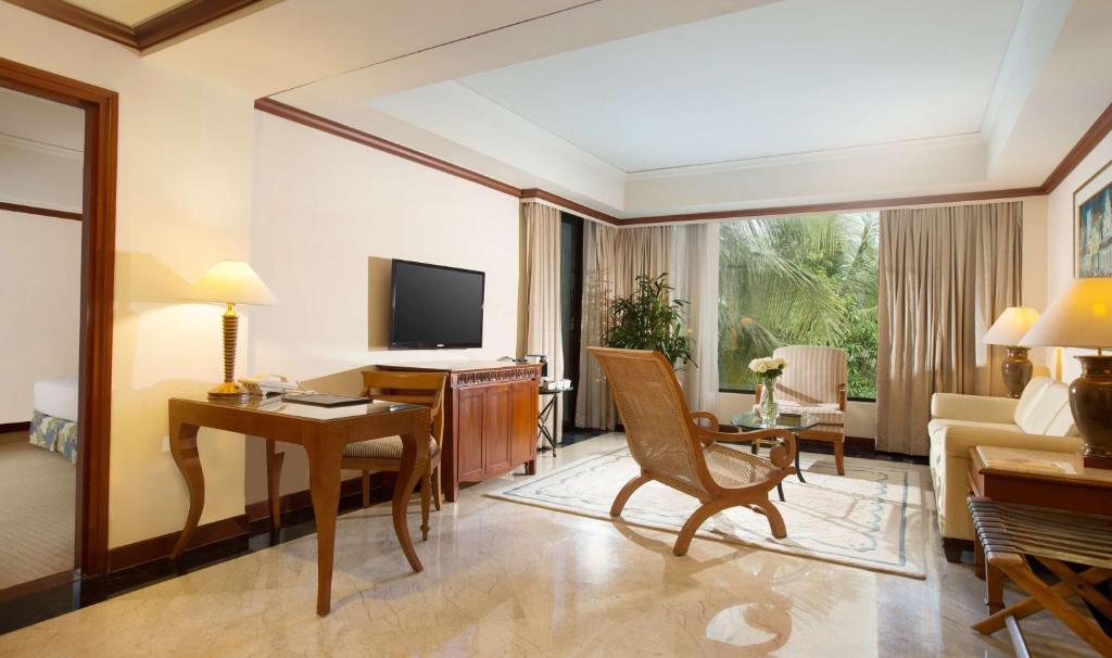 a living room with a desk and a television in a room at Hyatt Regency Yogyakarta in Yogyakarta