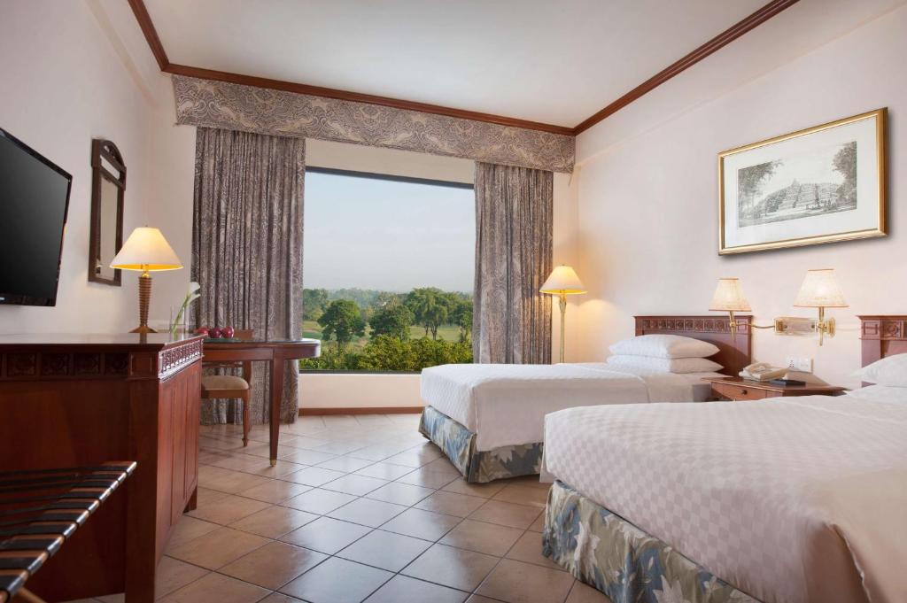 a hotel room with two beds and a large window at Hyatt Regency Yogyakarta in Yogyakarta