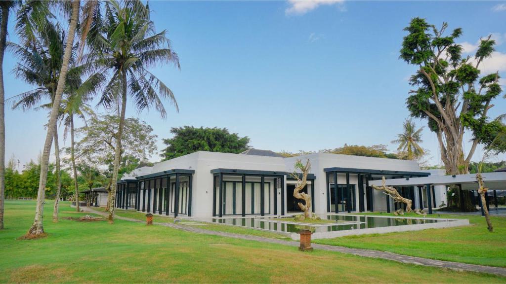 a building with palm trees in front of it at Hyatt Regency Yogyakarta in Yogyakarta