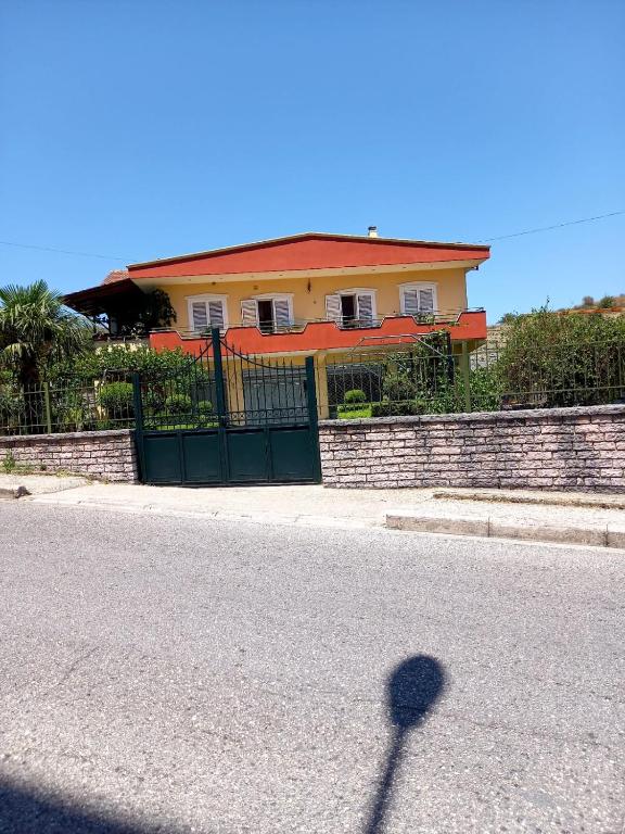 a shadow of a house with a fence and a street at GuestHouseMantho in Gjirokastër