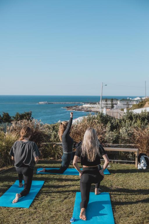 een groep vrouwen die yoga doet op het strand bij You and the sea in Ericeira