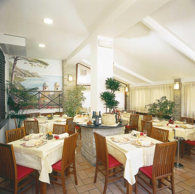a restaurant with tables and chairs and a painting on the wall at Hotel Ulivi in Arenzano