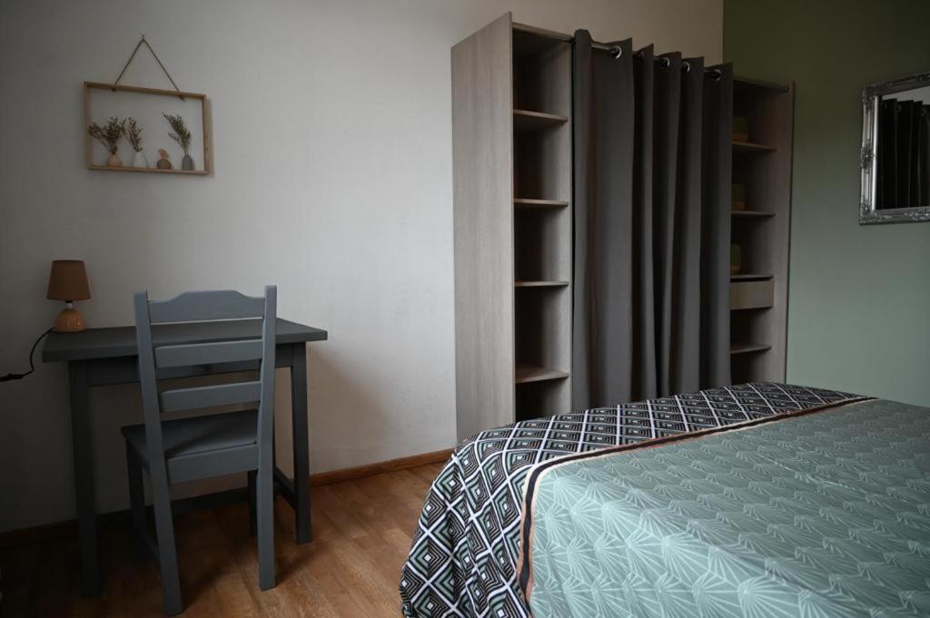 a bedroom with a desk and a bed and a table and chair at Grand appartement cosy-Hyper Centre-Place Verdun in Tarbes