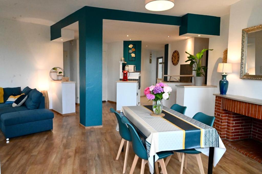 ein Wohnzimmer mit einem Tisch und einem blauen Sofa in der Unterkunft Grand appartement cosy-Hyper Centre-Place Verdun in Tarbes