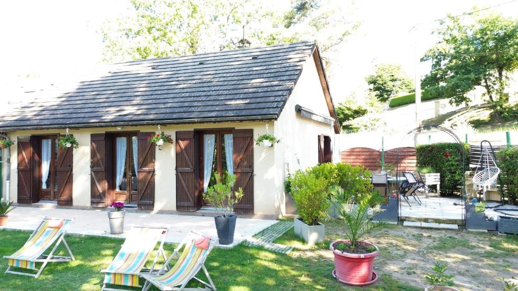 uma casa com cadeiras e uma mesa num quintal em Maison Du Lac em Marcillac-la-Croisille