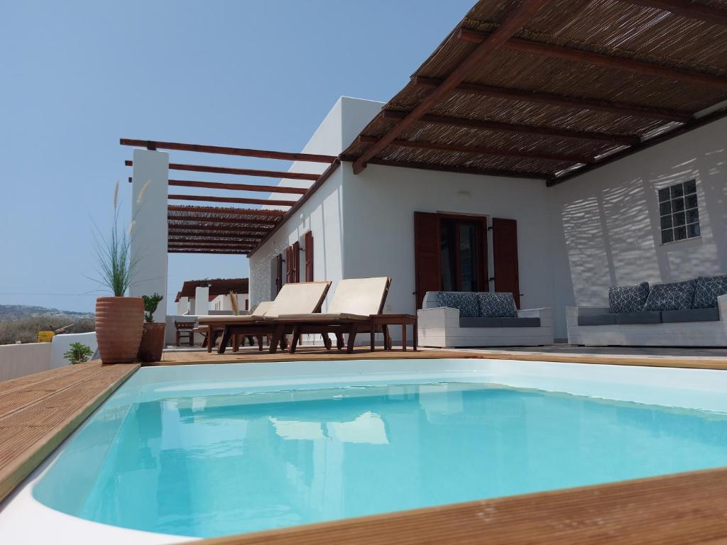 a swimming pool in front of a house at Sea breeze houses in Monolithos