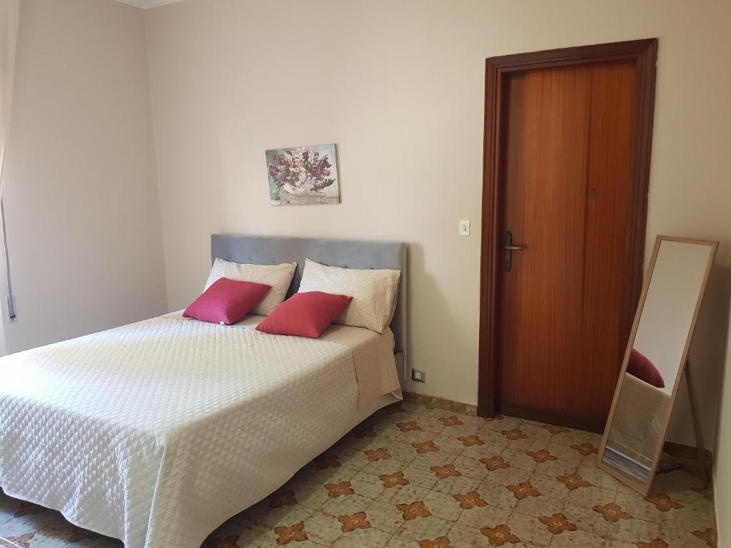 ein Schlafzimmer mit einem Bett mit zwei roten Kissen in der Unterkunft La Magnolia in San Giorgio a Liri