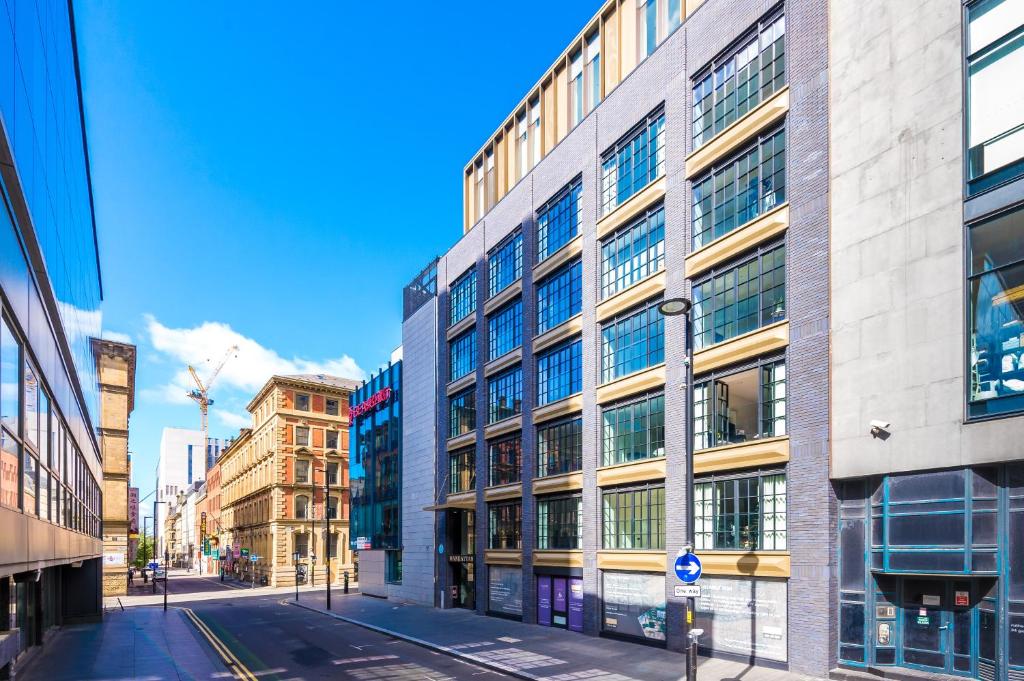un palazzo alto con molte finestre su una strada di Hilltop Serviced Apartments - Piccadilly a Manchester