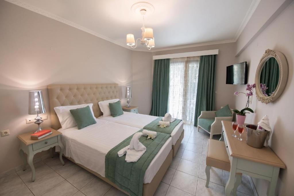 una camera con un grande letto bianco e una scrivania di Eva beach hotel a Nydri