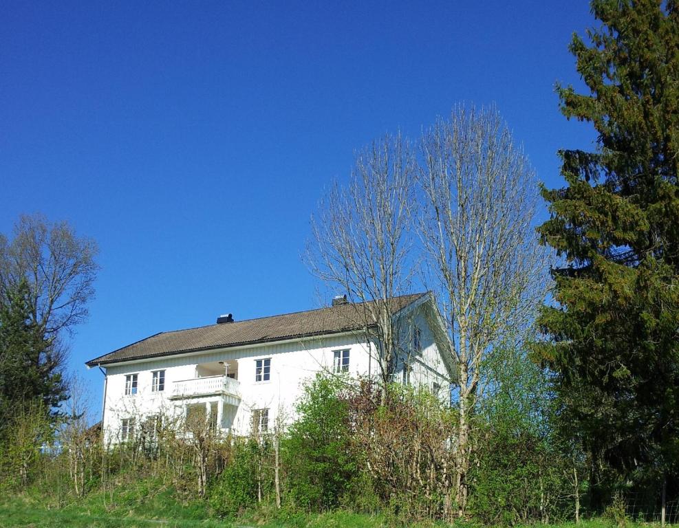 Sogn Lågensikt في Svarstad: منزل أبيض يجلس على قمة تلة