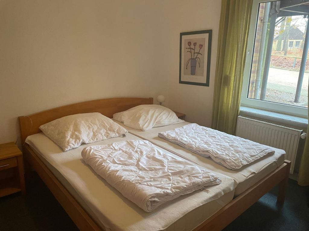 an unmade bed in a bedroom with a window at Seeblick Wohnung 102 mit Ostseeblick in Ostseebad Koserow