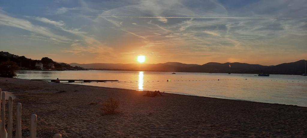 a sunset on a beach with the sun setting at Villa Playa del Sol -B4 in Saint-Tropez