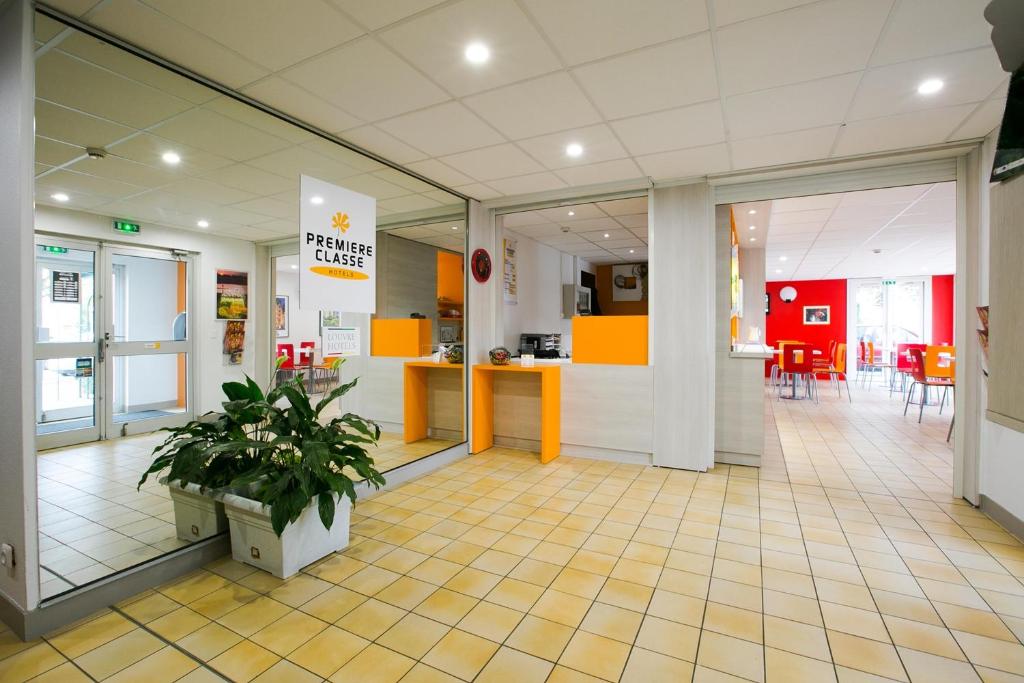 a lobby of a store with a potted plant in it at PREMIERE CLASSE ANGERS SUD Louvre Hotels group in Les Ponts-de-Cé