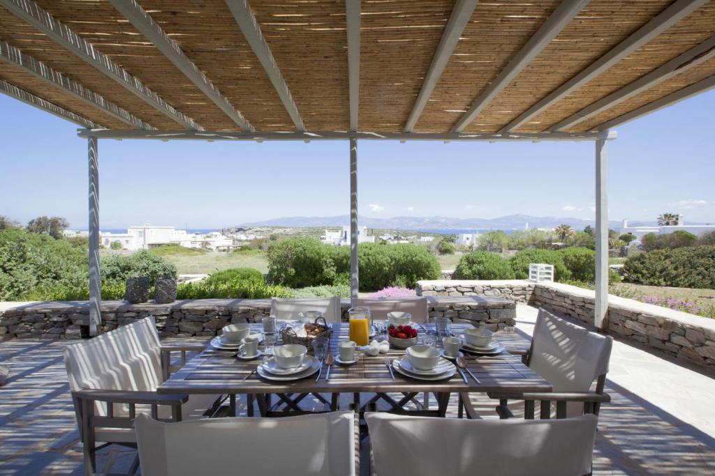 a table and chairs on a patio with a view at Kallisti Rodia - Dream Villa with Views Garden nr Best kid's Beach in Santa Maria