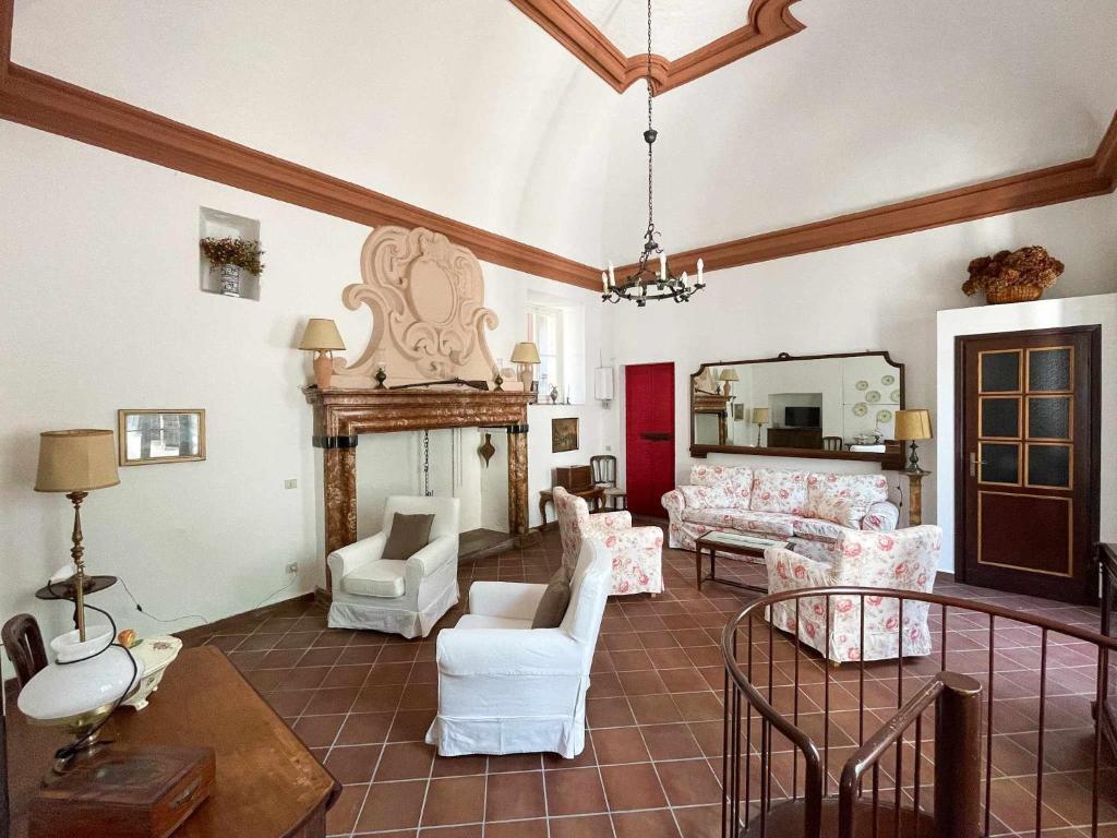 a living room with white furniture and a mirror at Il Convento Ancient Apartment with private garden in Bellagio