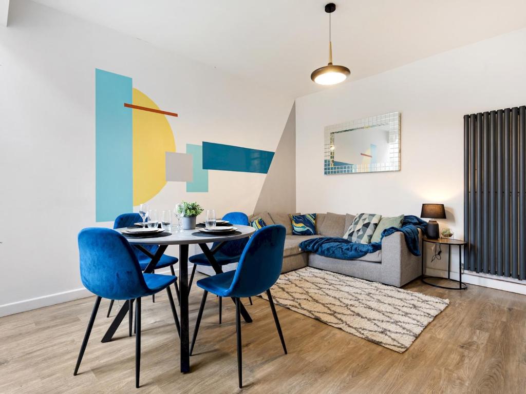 a living room with a table and blue chairs at Pass the Keys Cheerful 3 bed home in Manchester suburbs in Manchester