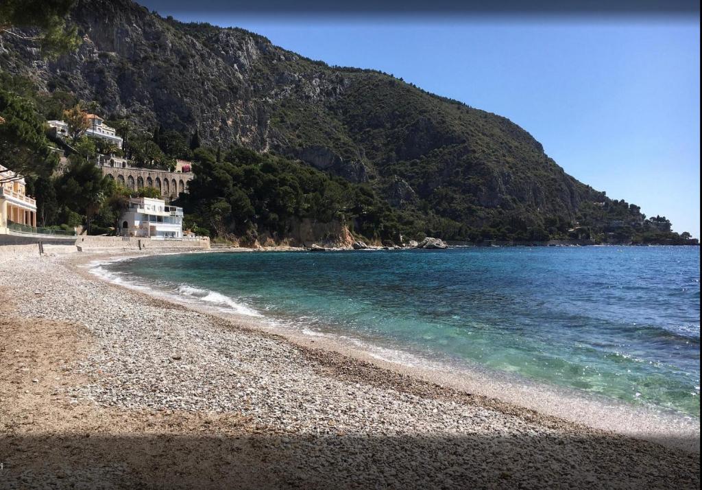 a beach with a rocky shore next to the water at Appartamento "Renata" in residence Cap Roux Eze Borde de Mer Costa Azzurra in Èze