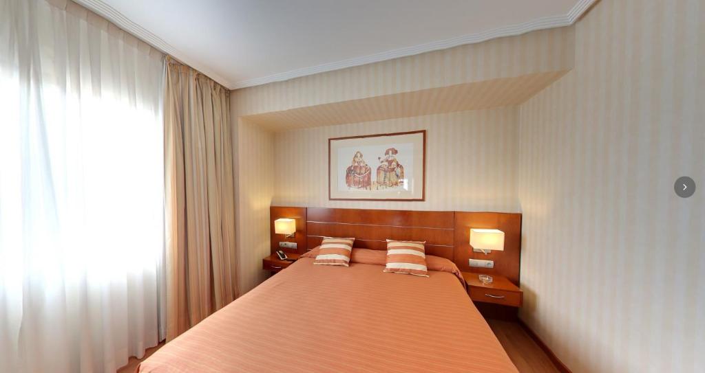 a bedroom with a large orange bed with two pillows at Checkin La Princesa in Móstoles