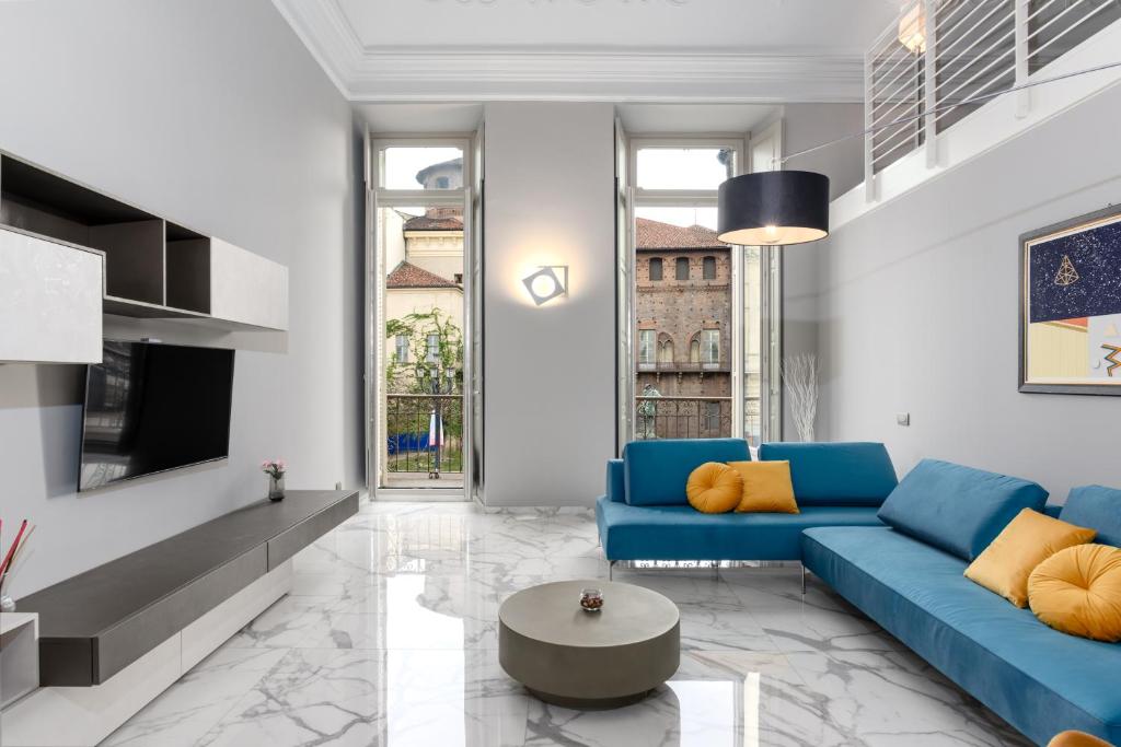 a living room with a blue couch and a tv at Q71 TIMELESS SUITES in Turin