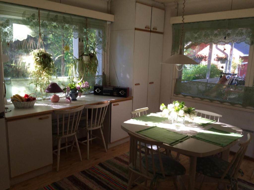 een keuken met een tafel met stoelen en een eetkamer bij Huone Seesteisessä Mummolassa in Kalajoki