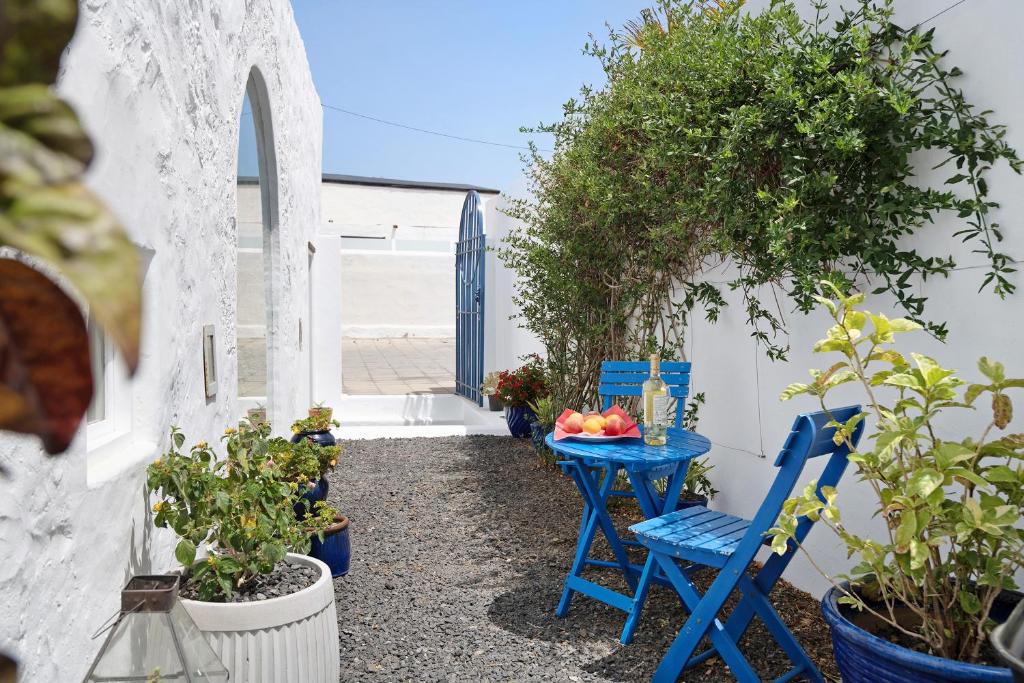 Mácher的住宿－El Piccolo，蓝色的桌子和椅子,位于一个享有海景的庭院