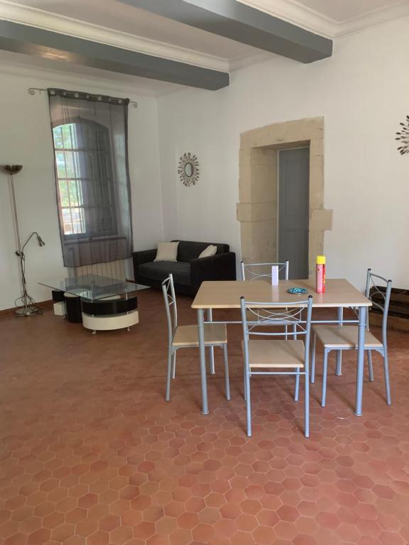 uma sala de estar com uma mesa e cadeiras e um sofá em Didgy 5 personnes em Pont-Saint-Esprit