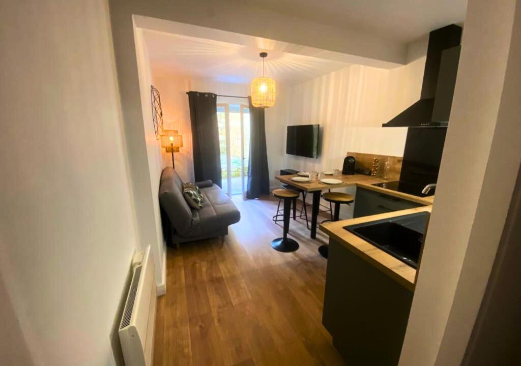 uma cozinha e sala de estar com um sofá e uma mesa em Côté Cour - Poitiers - La Conciergerie. em Poitiers