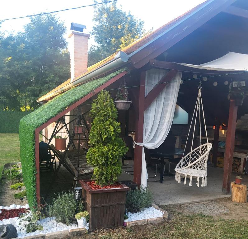 ein Haus mit einer Veranda mit einer Schaukel in der Unterkunft Cottage in Apatin