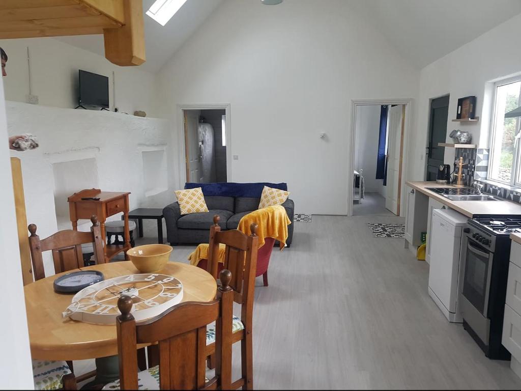a kitchen and living room with a table and a couch at Lavender lane cottage in Tralee