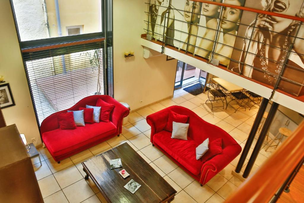 a living room with two red chairs and a table at Lofts Duplex et Triplex Vieux Port Cannes in Cannes