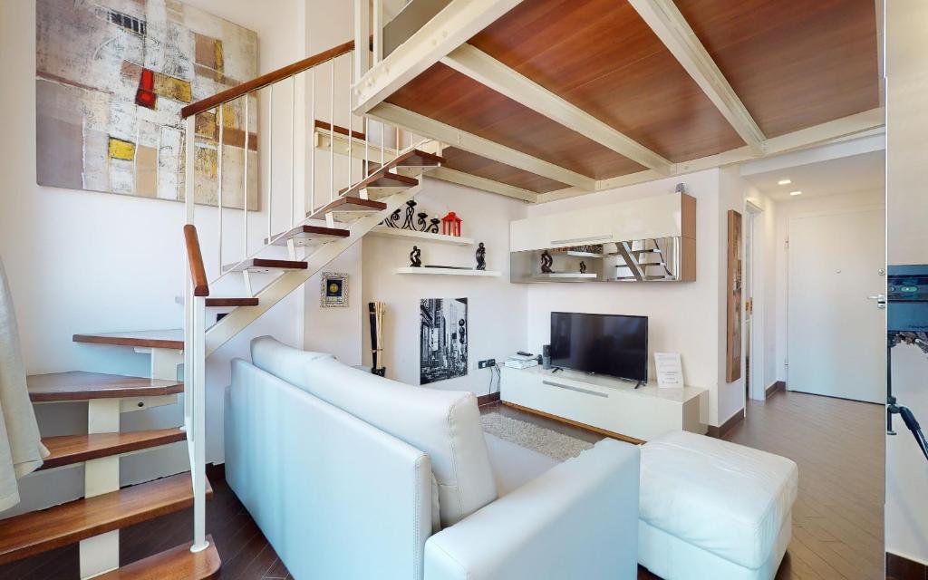Una sala de estar con un sofá blanco y un televisor. en Open Space Martina, en Rávena