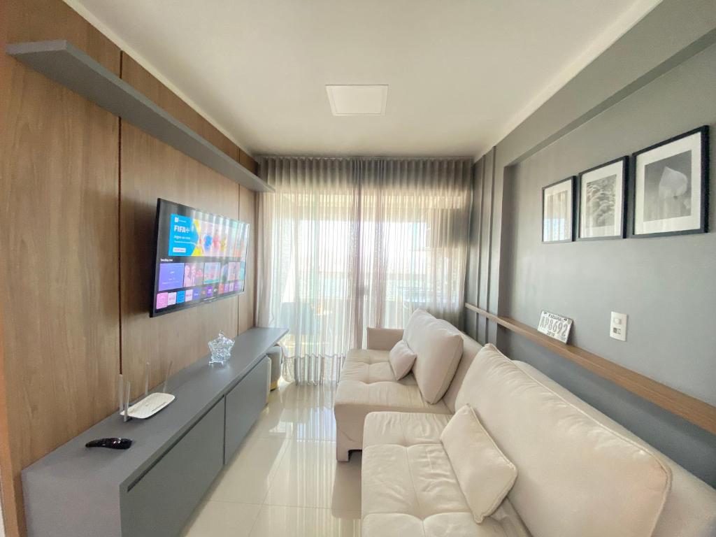 sala de estar con sofá blanco y TV en Luxuoso 2Q St Bueno - 3101, en Goiânia
