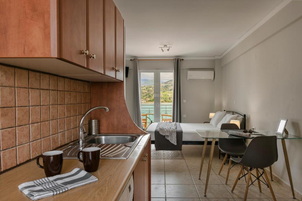 kuchnia ze zlewem oraz pokój z łóżkiem w obiekcie Fidias city rooms w mieście Argostoli