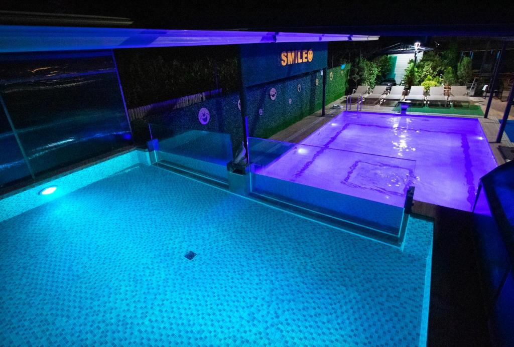 een zwembad met blauwe verlichting in een gebouw bij Hotel Smile in Kobuleti