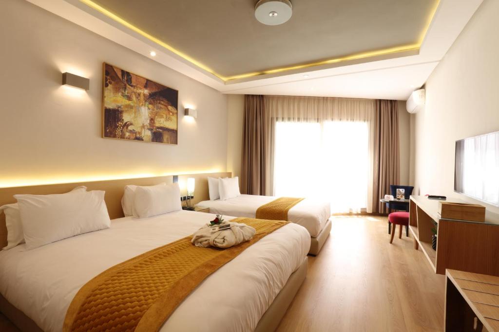 a hotel room with two beds and a television at Silver Suites Hotel Casablanca in Casablanca