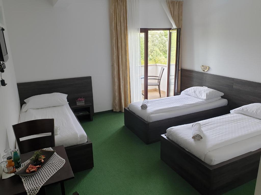 Habitación de hotel con 2 camas, mesa y sillas en Hotel Lohovo, en Lohovo